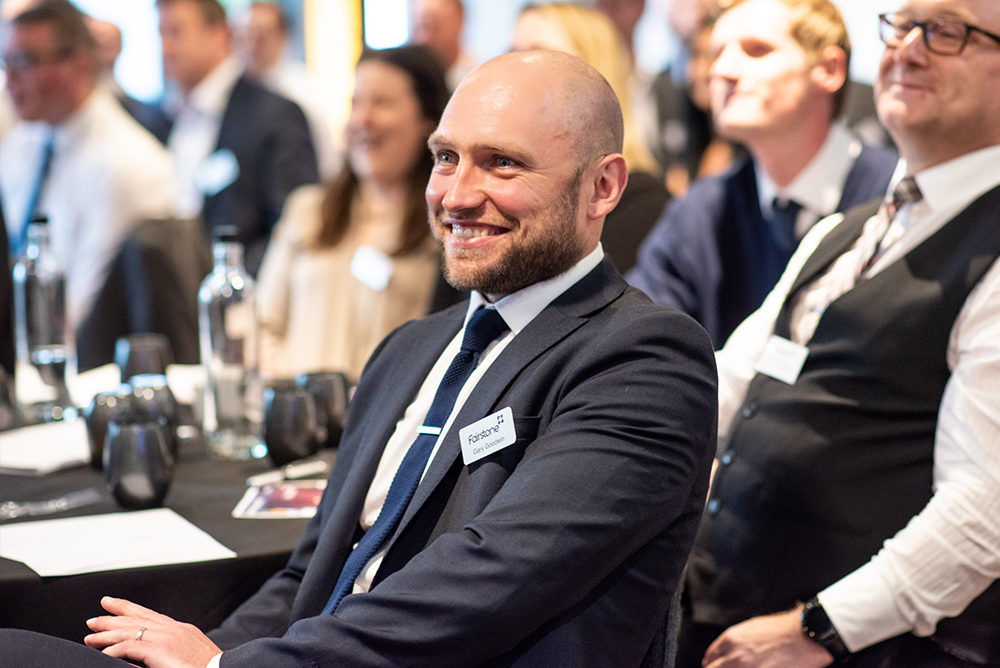 Fairstone employee sits and smiles whilst attending Fairstone annual conference