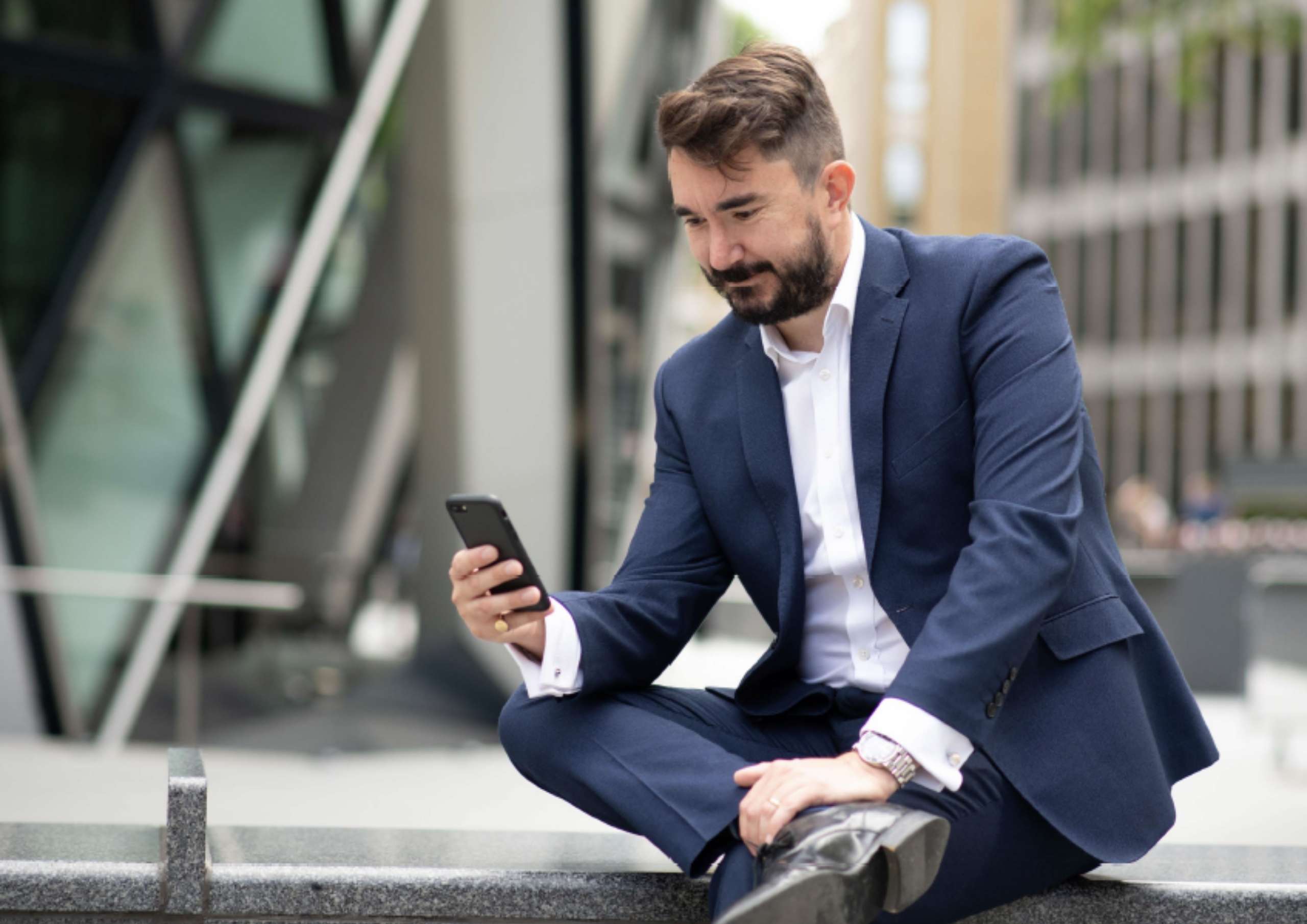 A man looking at his phone and smiling